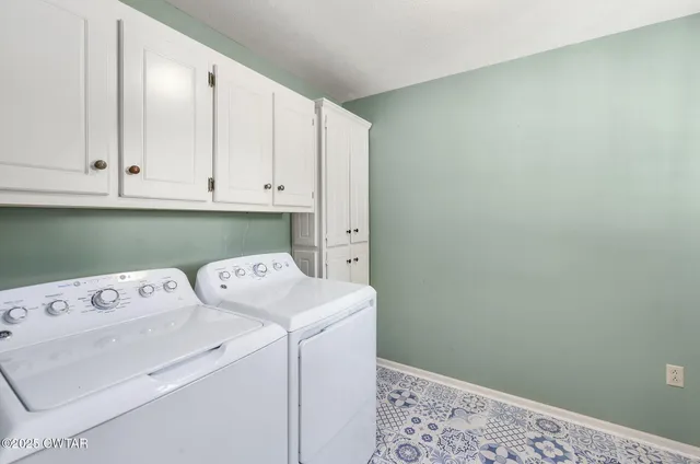 a view of washer and dryer with bathroom in the background