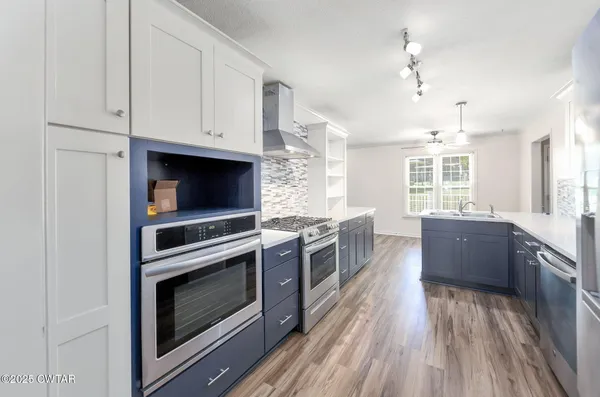 a kitchen with stainless steel appliances a stove a sink and a refrigerator