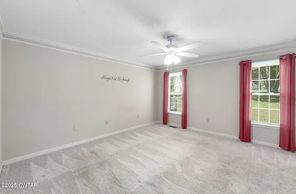 an empty room with windows and fan