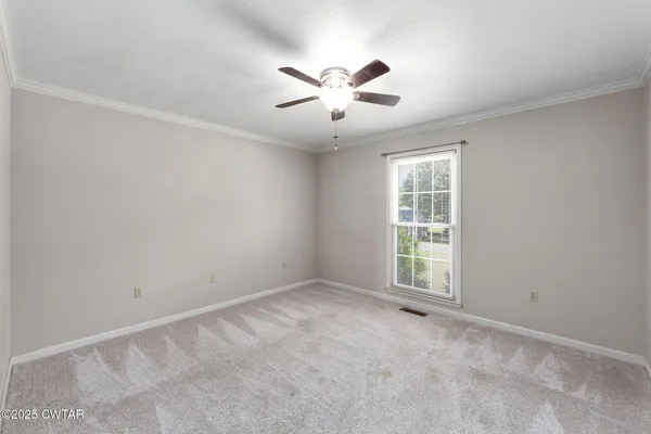 an empty room with windows and ceiling fan