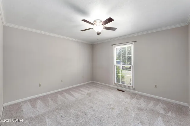 an empty room with windows and ceiling fan