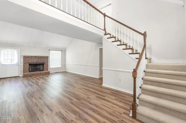 a view of staircase with wooden floor and a fireplace