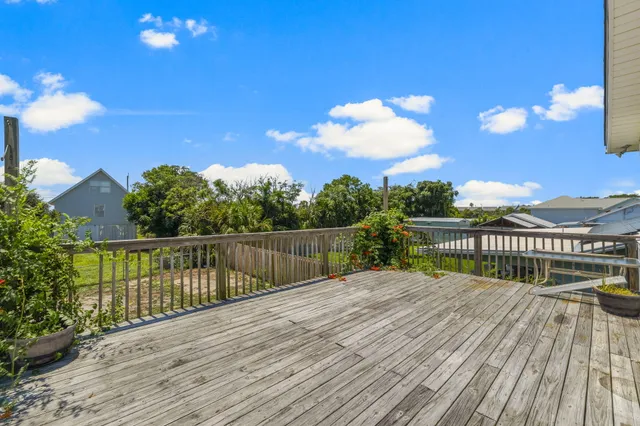 a view of a balcony with wooden floor and fence