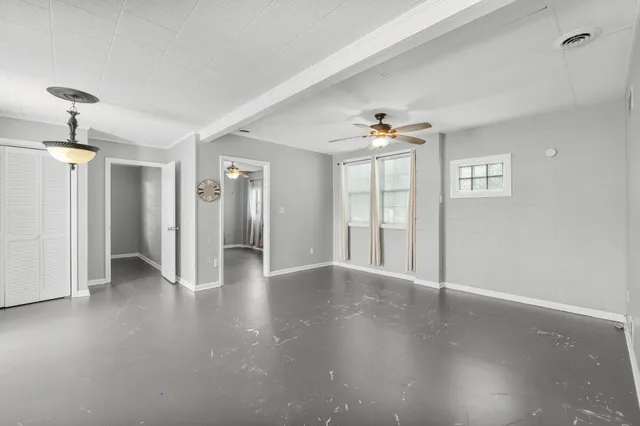 an empty room with a ceiling fan and wooden floor