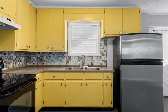 an empty room with wooden floor window and ceiling fan