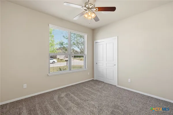 an empty room with chandelier fan