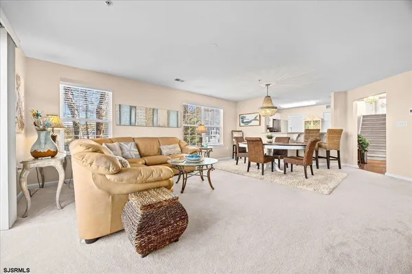 a living room with furniture a dining table and a window