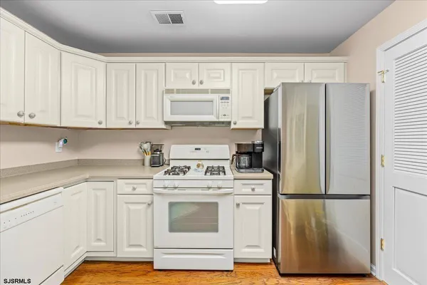 a dining room with furniture a chandelier and wooden floor