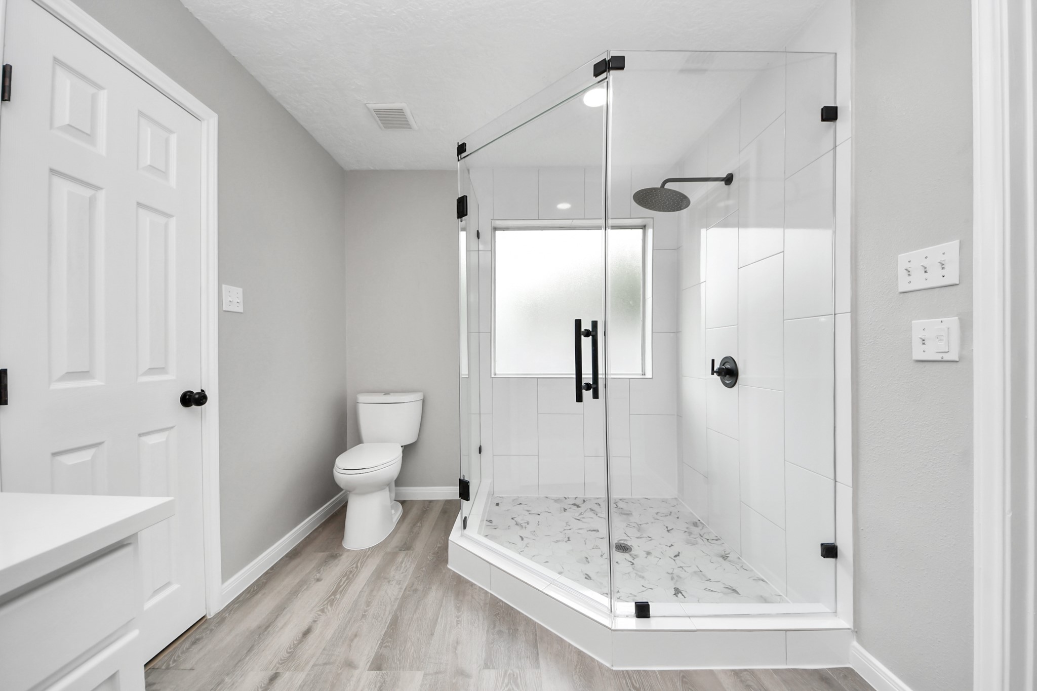1105 East Kyle Road Clute, TX 77531 - Photo 26 of 44 This modern bathroom features a spacious glass-enclosed shower with sleek fixtures and white tile. It has a clean and contemporary look.