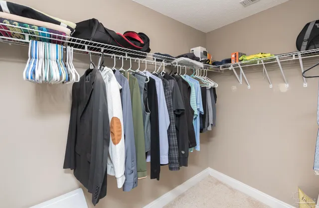 a view of walk in closet with clothes and shoes
