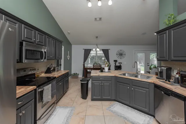 a kitchen with stainless steel appliances a sink dishwasher stove top oven and refrigerator