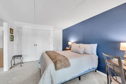 a bedroom with a large bed and a lamp next to a window