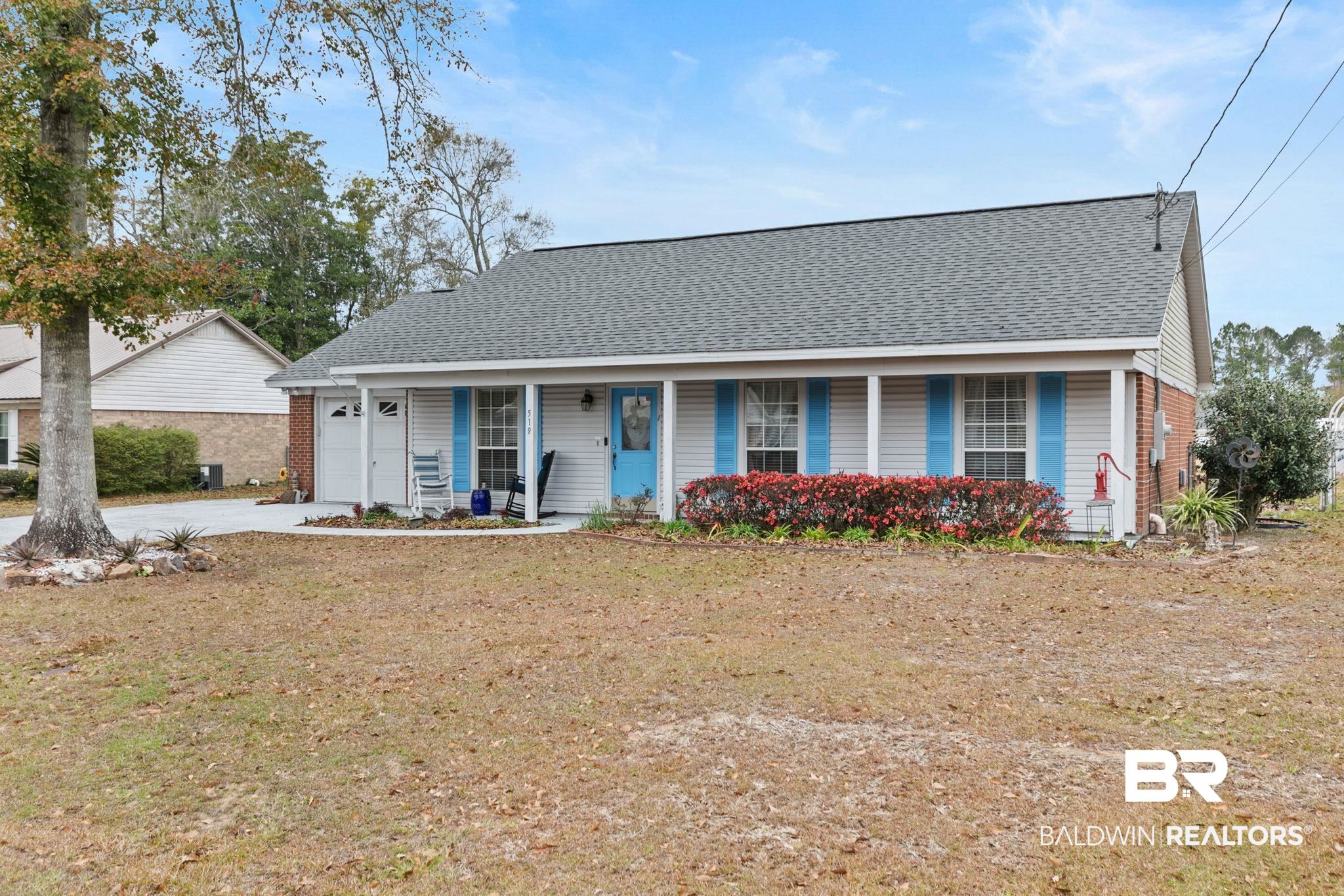 519 Juniper Place Drive Foley, AL 36535 - Photo 1 of 47 View of front of property featuring a shingled roof, covered porch, driveway, and a front lawn