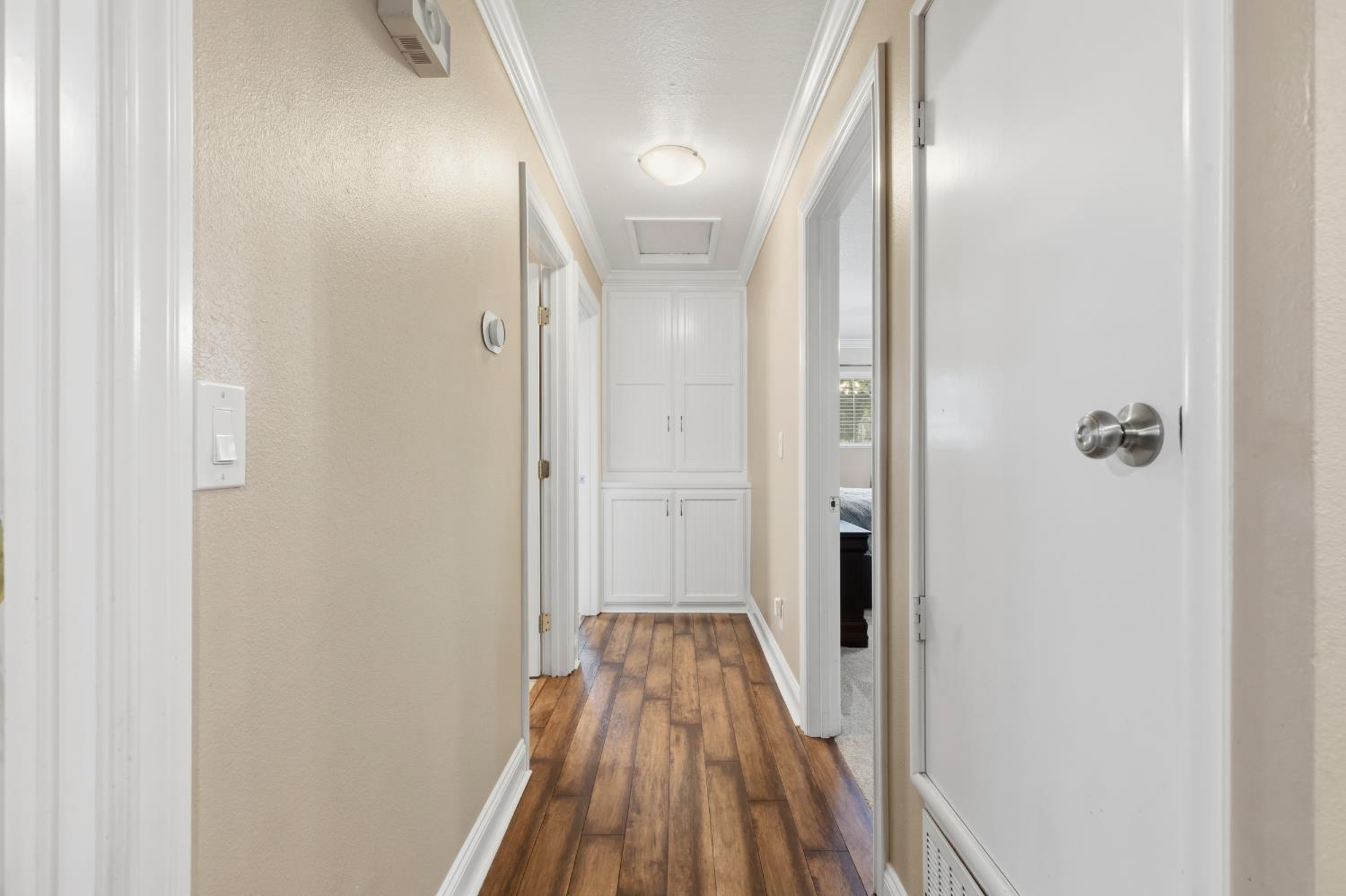 550 Bell Street Turlock, CA 95380 - Photo 14 of 36 a view of a hallway with wooden floor and a bathroom