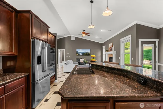a kitchen with kitchen island a counter top space a sink stainless steel appliances and cabinets
