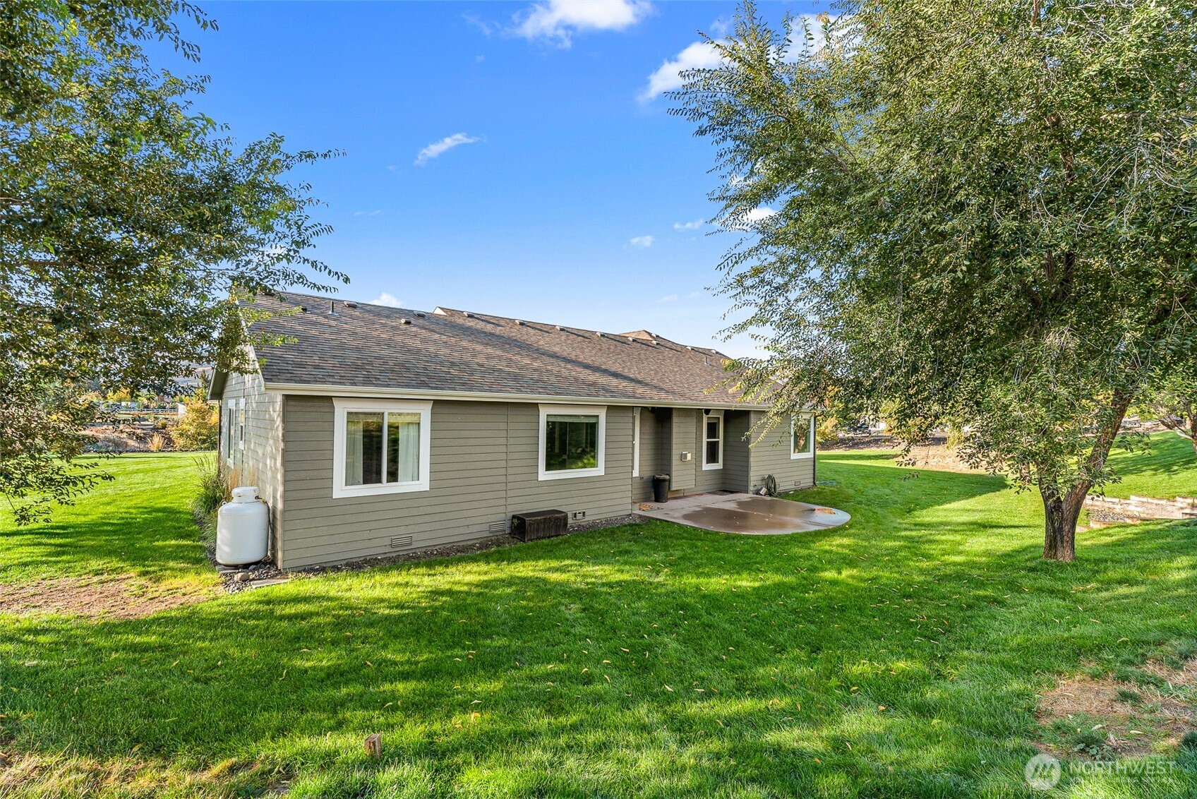 2945 Martin Place East Wenatchee, WA 98802 - Photo 33 of 40 a backyard of a house with plants and large tree