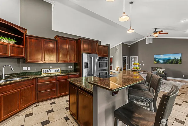 a kitchen with stainless steel appliances granite countertop a sink stove and refrigerator