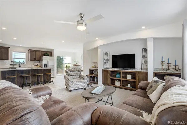 a living room with furniture kitchen view and a flat screen tv