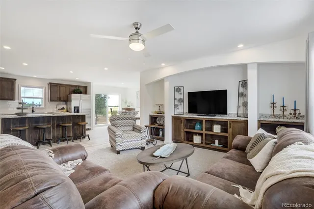 a living room with furniture kitchen view and a flat screen tv