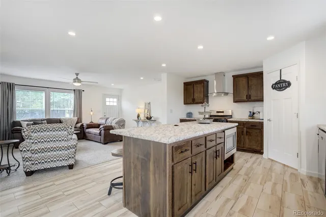 a large kitchen with stainless steel appliances granite countertop a lot of counter space and wooden floor