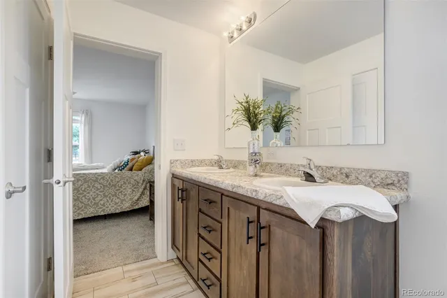 a en suite bathroom with a granite countertop sink and a mirror