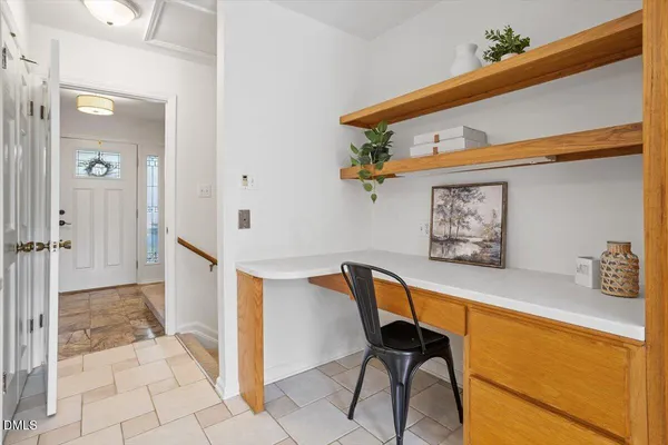 a view of a hallway to a livingroom with furniture and a window