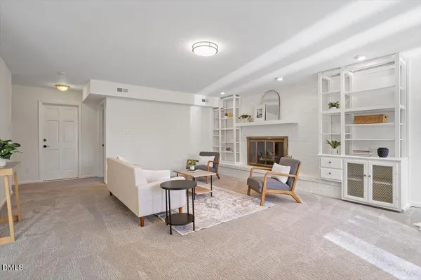 a living room with furniture a fireplace and a large window