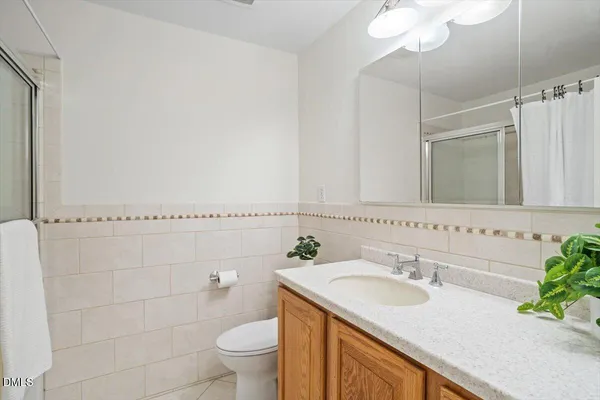 a bathroom with a granite countertop sink a toilet and a mirror