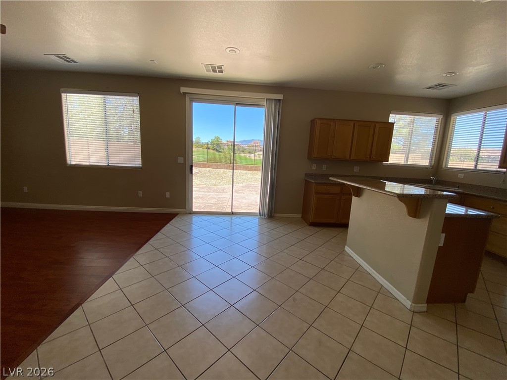 489 Foster Springs Road Las Vegas, NV 89148 - Photo 3 of 30 Sliding glass doors open to a sun-drenched outdoor view, complementing the stylish kitchen and living area.