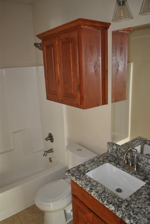 412 Dewitt Street Collinsville, TX 76233 - Photo 13 of 17 a bathroom with a granite countertop sink toilet and shower