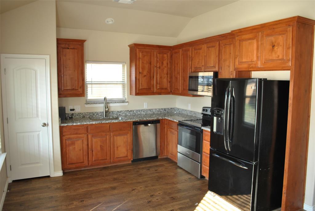 412 Dewitt Street Collinsville, TX 76233 - Photo 3 of 17 a kitchen with granite countertop stainless steel appliances a refrigerator and cabinets
