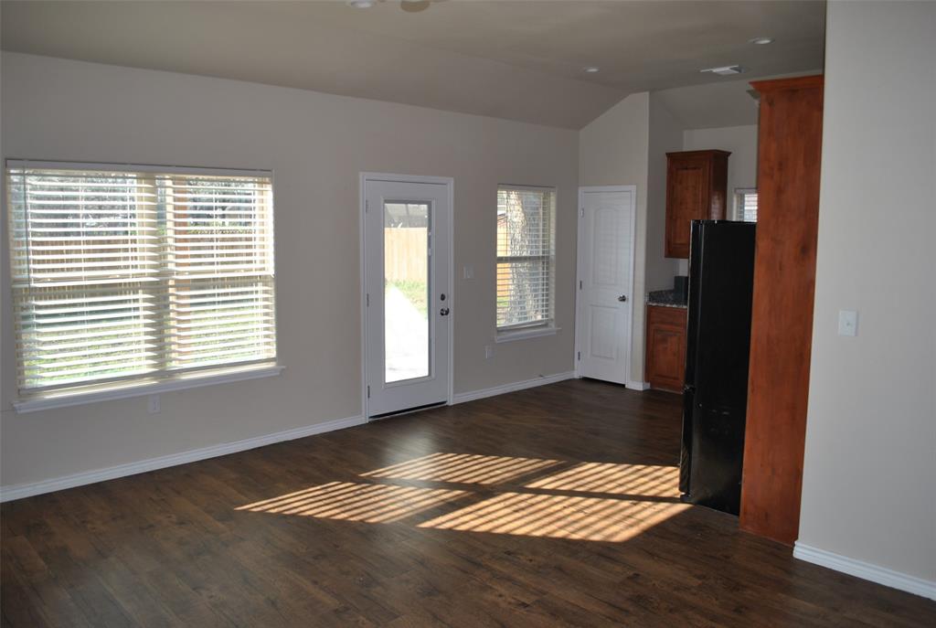 412 Dewitt Street Collinsville, TX 76233 - Photo 4 of 17 a view of an empty room with wooden floor and a window