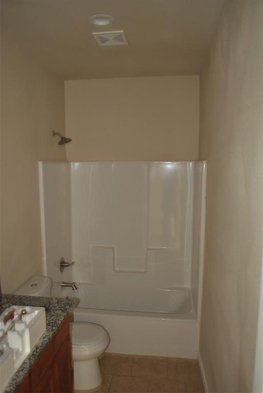 412 Dewitt Street Collinsville, TX 76233 - Photo 5 of 17 a bathroom with a granite countertop bathtub shower sink vanity and toilet