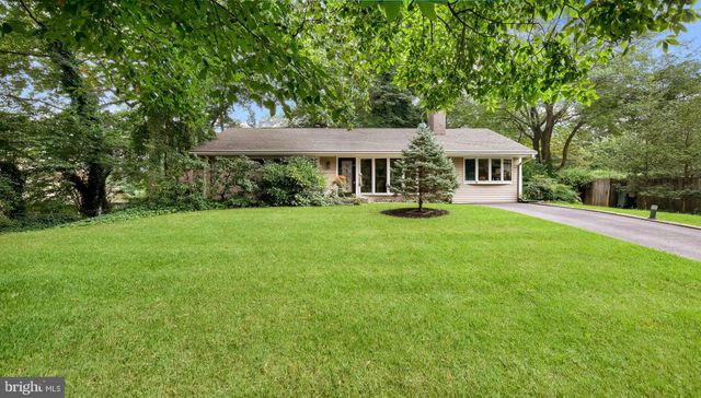 a front view of a house with a yard and trees