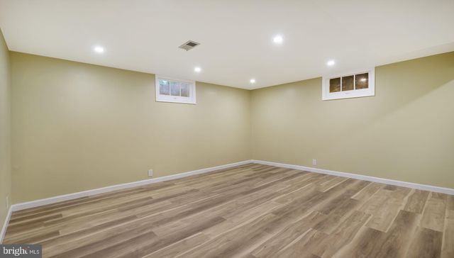 a view of room with wooden floor and fan