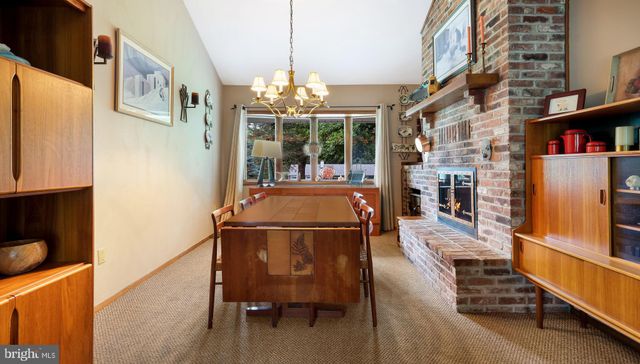 a view of a dining room with furniture a chandelier and wooden floor