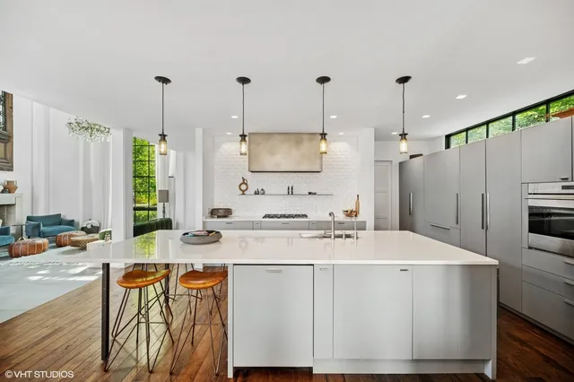 a kitchen with stainless steel appliances kitchen island granite countertop a sink a stove and a refrigerator