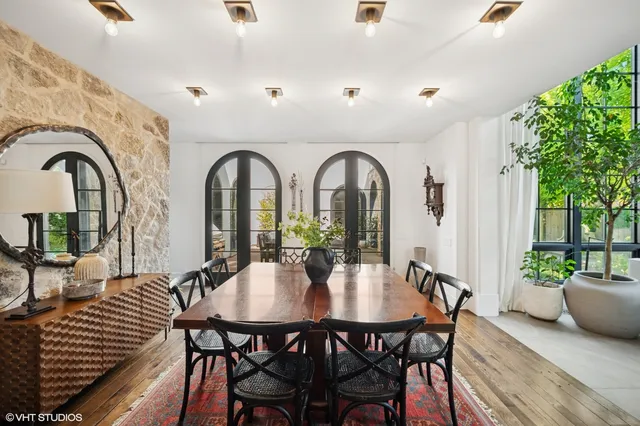 a view of a dining room with furniture and potted plants
