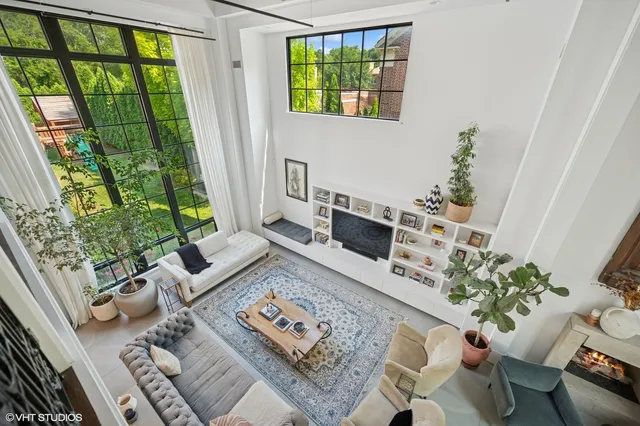 a living room with furniture fireplace and a large window
