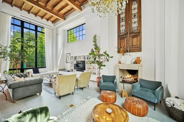 a living room with furniture fireplace and a large window
