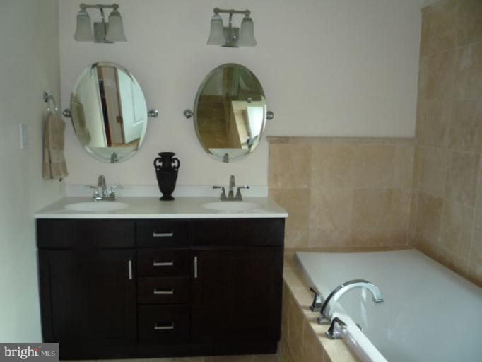 20300 Whites Ferry Road Poolesville, MD 20837 - Photo 7 of 30 a bathroom with a double vanity sink and mirror
