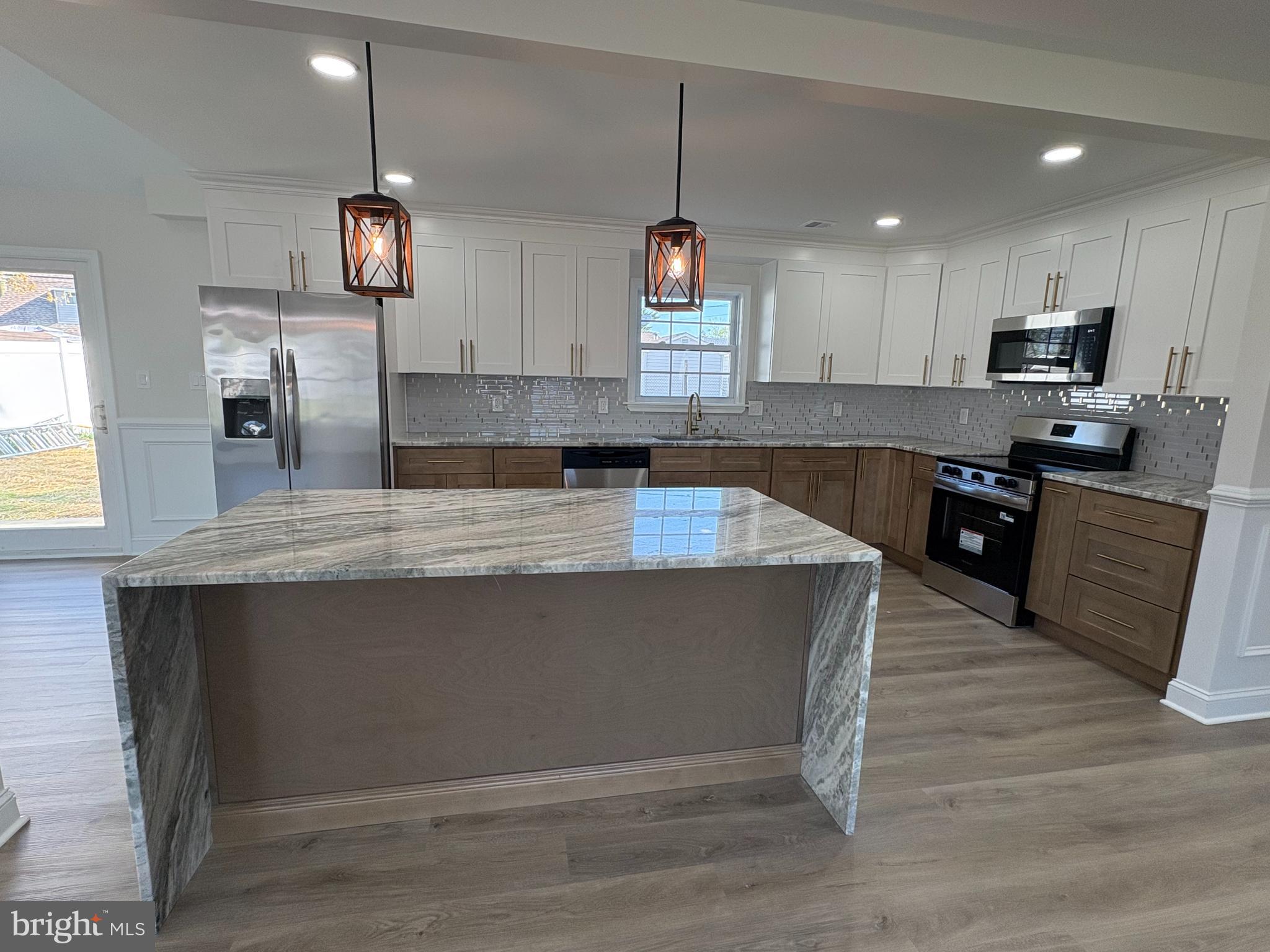 50 Micahill Road Levittown, PA 19056 - Photo 11 of 45 a large kitchen with stainless steel appliances granite countertop a stove a sink a refrigerator a center island and wooden floor