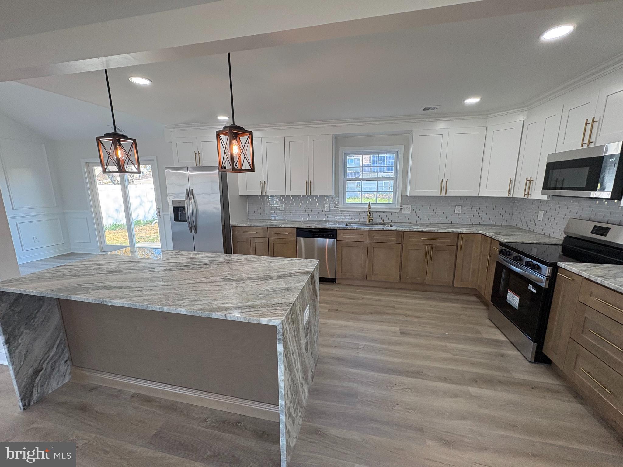 50 Micahill Road Levittown, PA 19056 - Photo 14 of 45 a kitchen with stainless steel appliances granite countertop wooden cabinets a sink dishwasher a stove and a wooden floors