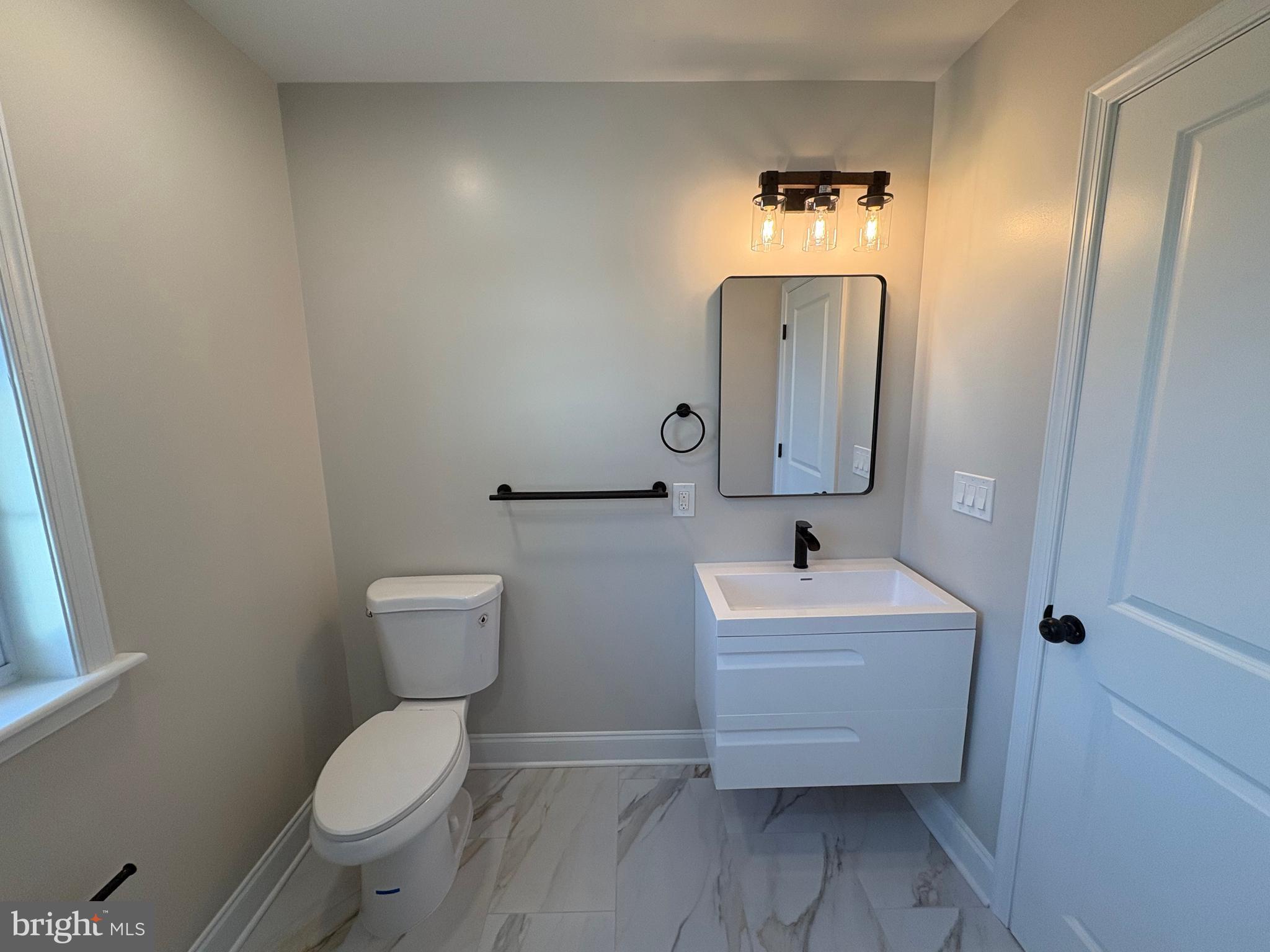 50 Micahill Road Levittown, PA 19056 - Photo 31 of 45 a bathroom with a sink mirror and toilet