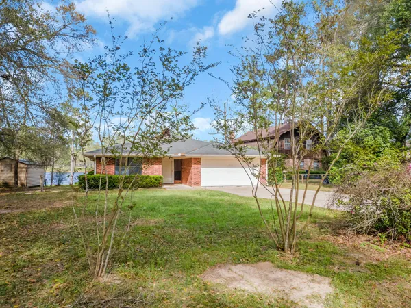 a view of a yard in front of a house with a tree