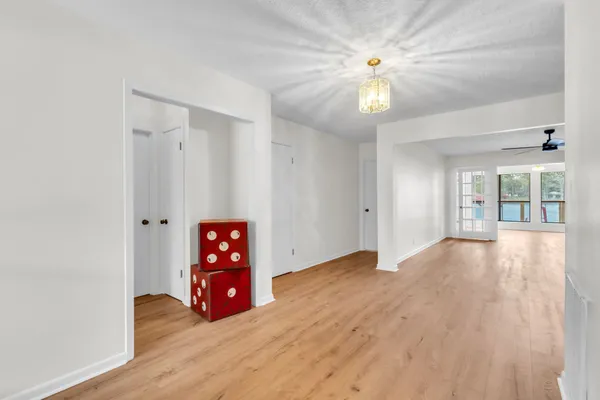 a view of an empty room with window and wooden floor