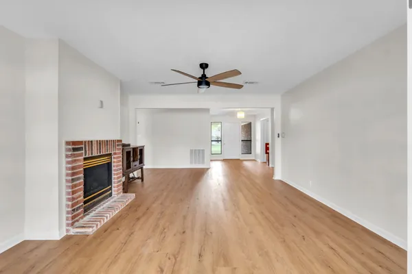 a view of empty room with wooden floor and fireplace