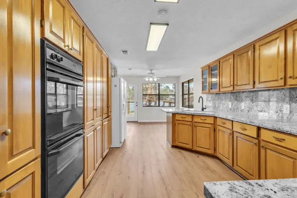 a kitchen with stainless steel appliances granite countertop a refrigerator a stove and a sink with cabinets