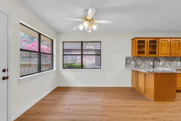 a view of an empty room with window and wooden floor