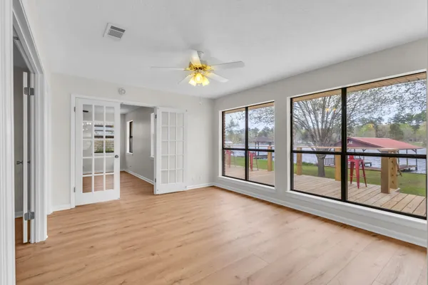 a view of an empty room with wooden floor and a window